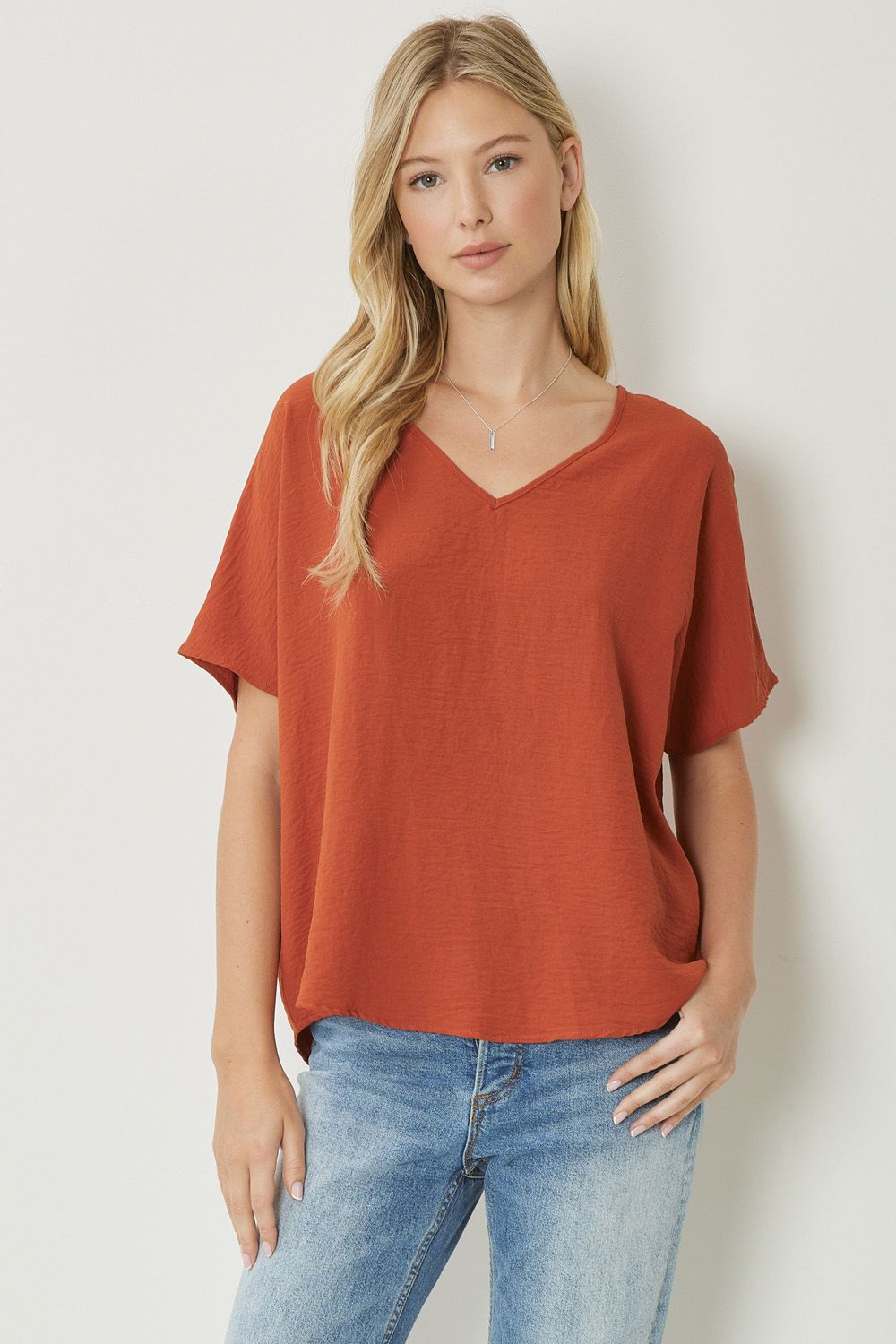 Solid v-neck top featuring asymmetric rounded hem detail. Unlined - 3 Colors