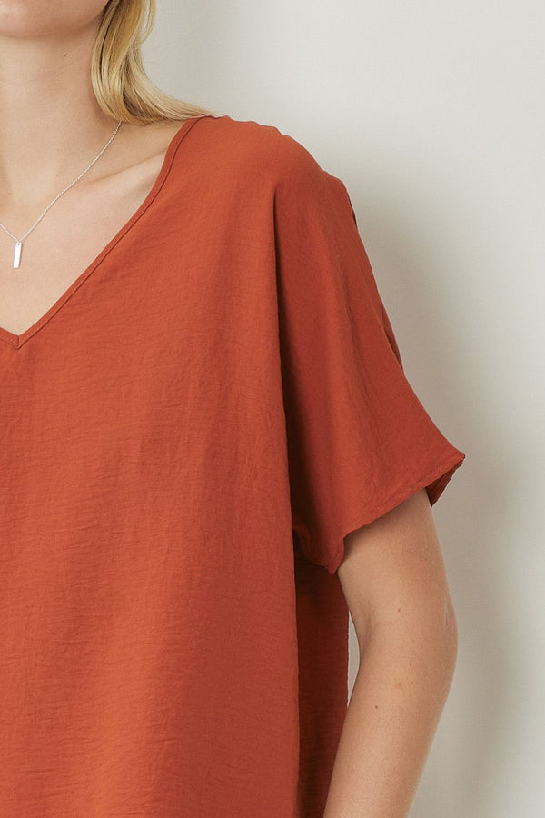 Solid v-neck top featuring asymmetric rounded hem detail. Unlined - 3 Colors